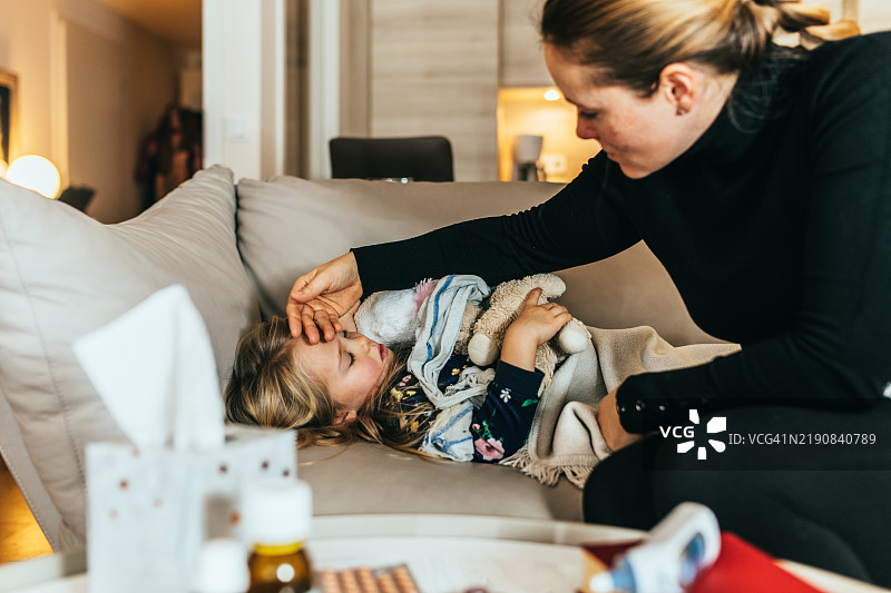 母亲用手检查孩子的体温。图片素材