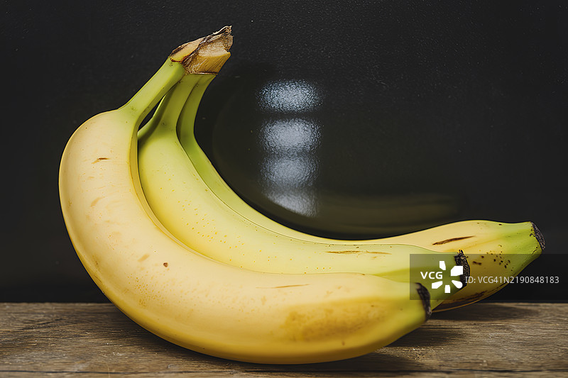 几根新鲜的香蕉在黑色背景上图片素材