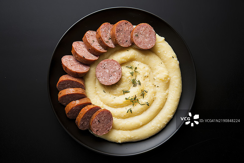 一盘切片熟香肠和玉米粥的孤立镜头图片素材