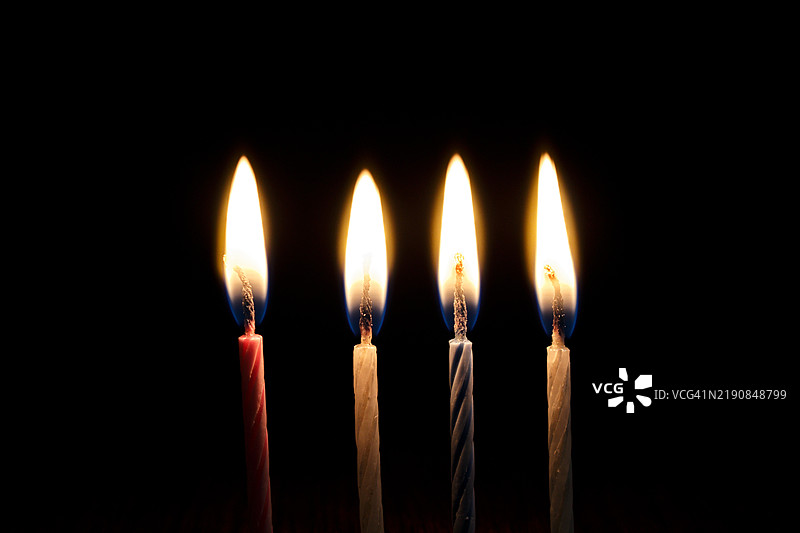 黑色背景下燃烧蜡烛的特写图片素材