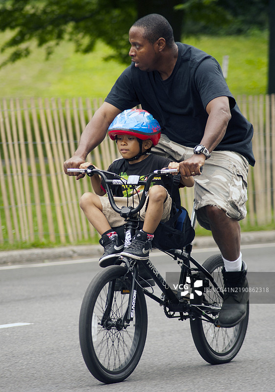 父亲和儿子在纽约市曼哈顿的中央公园骑自行车。图片素材