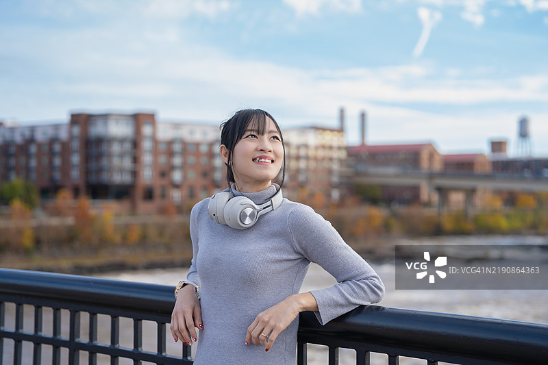 在美国哥伦布市，一位自信的亚洲女性在城市环境中站立，散发出美丽和现代优雅，体现出一种赋权的生活方式。图片素材