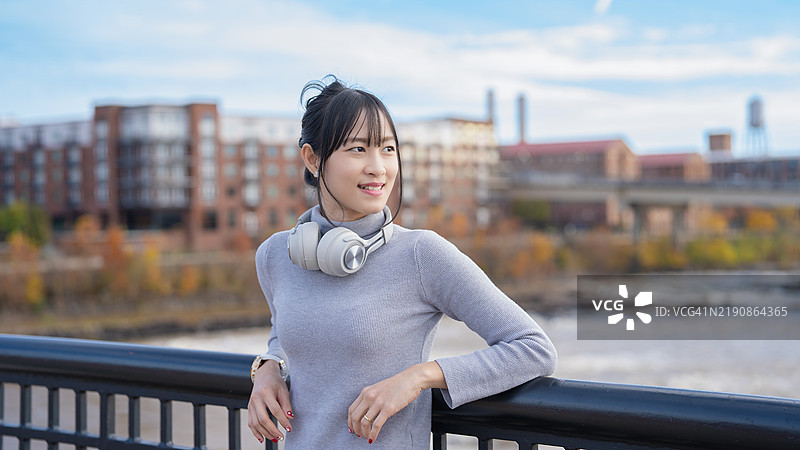 在美国哥伦布市，一位自信的亚洲女性在城市环境中站立，散发出美丽和现代优雅，体现出一种赋权的生活方式。图片素材