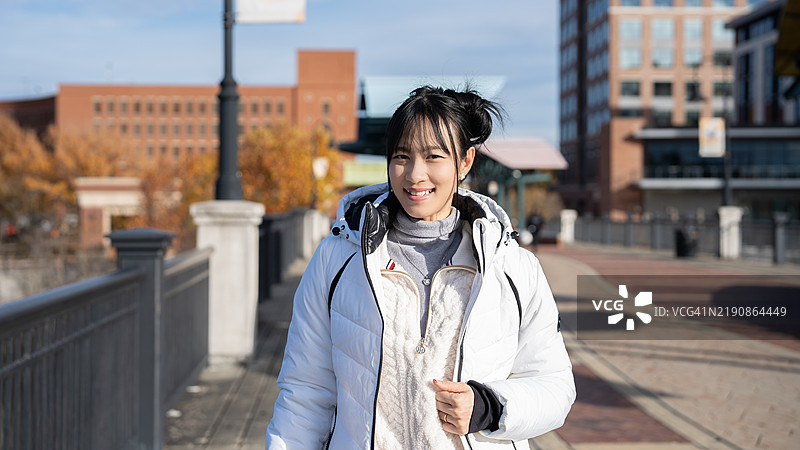 在美国哥伦布市，一位自信的亚洲女性在城市环境中站立，散发出美丽和现代优雅，体现出一种赋权的生活方式。图片素材