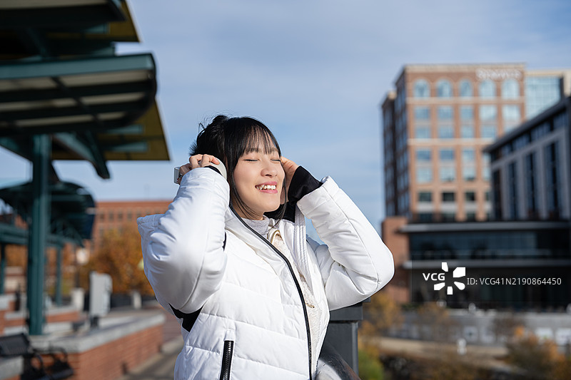 在美国哥伦布市，一位自信的亚洲女性在城市环境中站立，散发着美丽和现代优雅，体现出一种赋权的生活方式。图片素材