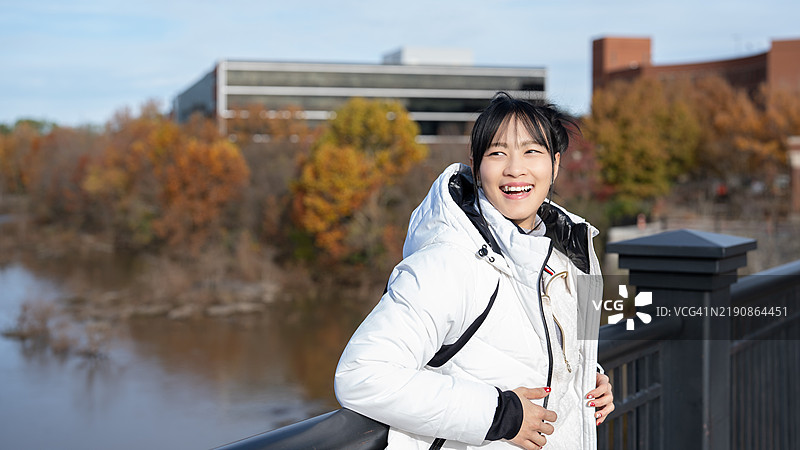 在美国哥伦布市，一位自信的亚洲女性在城市环境中站立，散发出美丽和现代优雅，体现出一种赋权的生活方式。图片素材