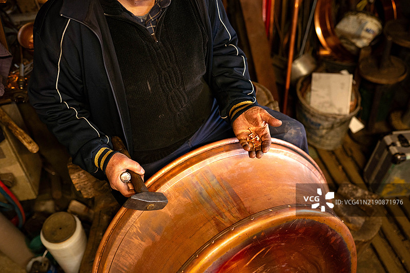 铜匠手工锻造铜金属。图片素材