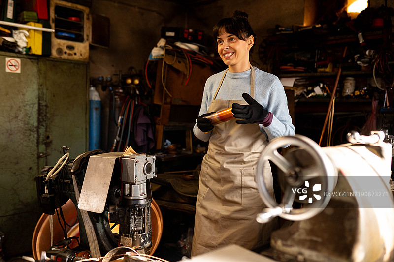 一位女性正在制作铜器图片素材