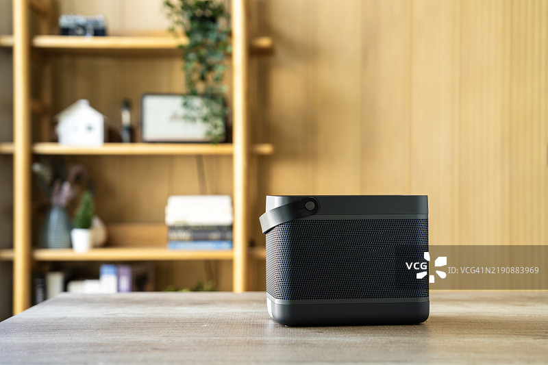 现代便携式音响放在简约风格的客厅木桌上图片素材