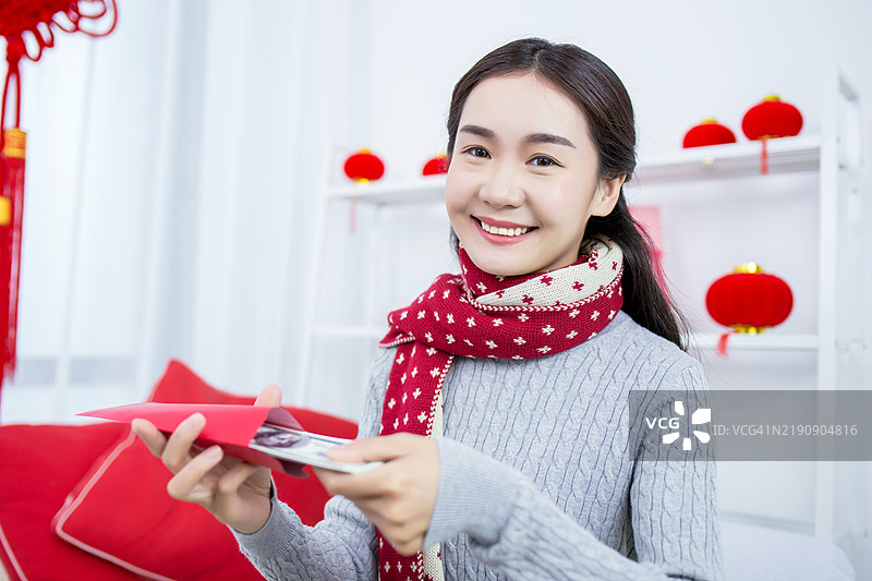 年轻的亚洲女性在春节时手持红包图片素材