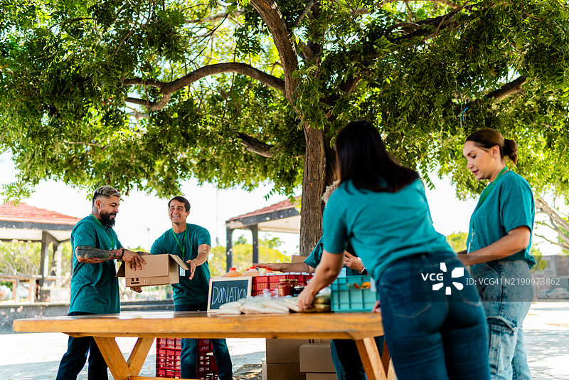 志愿者在户外交谈并整理捐赠箱图片素材