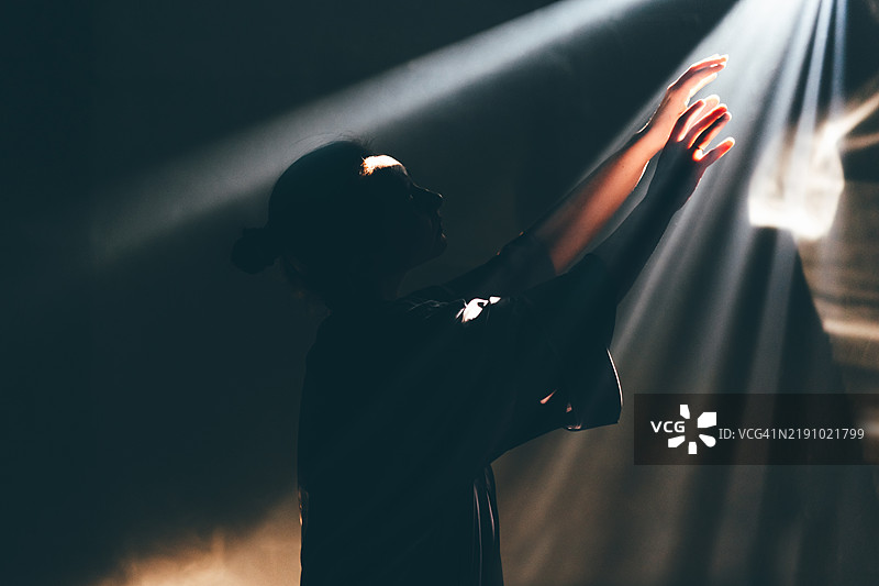 无法辨认的女性在阳光下握手。希望的概念。图片素材