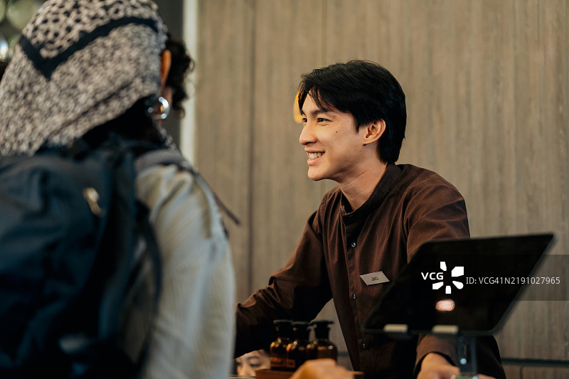 友好的酒店礼宾为客人提供专业的微笑服务图片素材