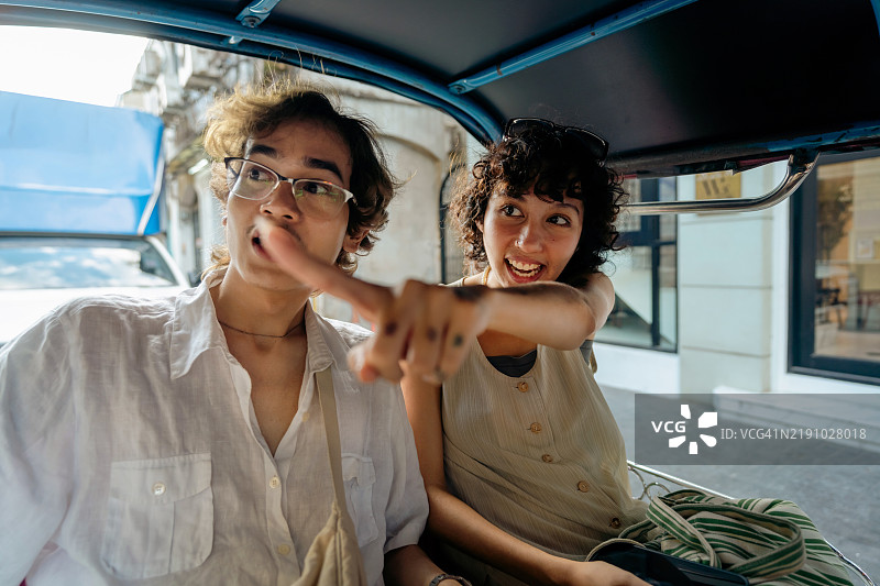 朋友们在城市中乘坐嘟嘟车时的亲密瞬间图片素材