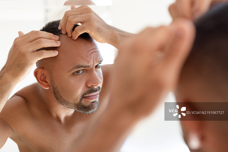 男性在检查自己的头发图片素材