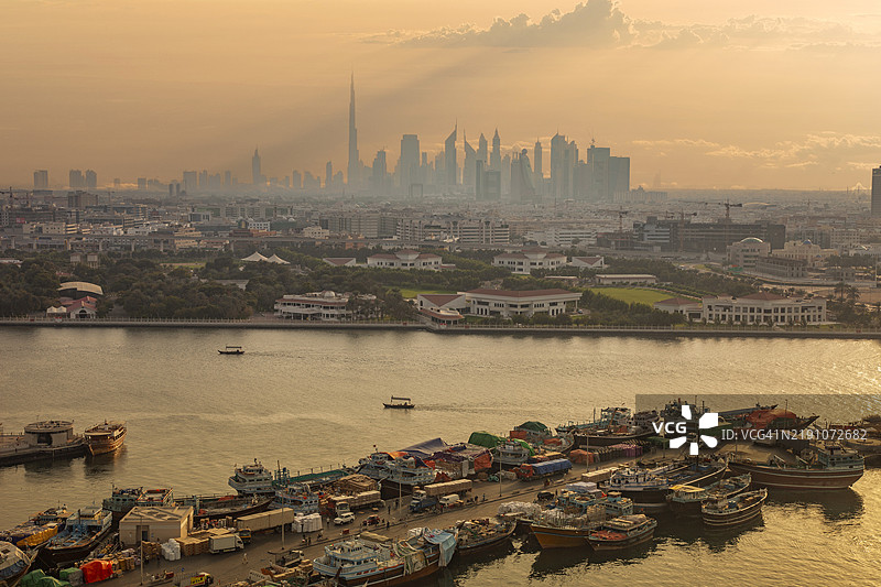 迪拜。传统阿拉伯船（达豪）停靠在迪拜溪，背景是迪拜天际线。图片素材