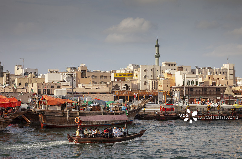 迪拜。传统阿拉伯船（达豪）和水上出租车（阿布拉）在迪拜溪。图片素材