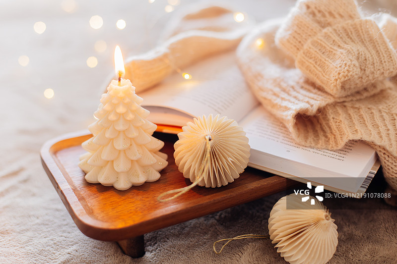 温馨的冬季场景，蜡烛、书籍和圣诞装饰图片素材