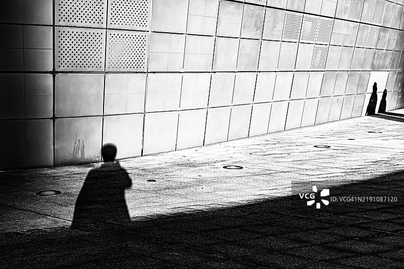 影子游戏：瓷砖墙上的光与形状图片素材