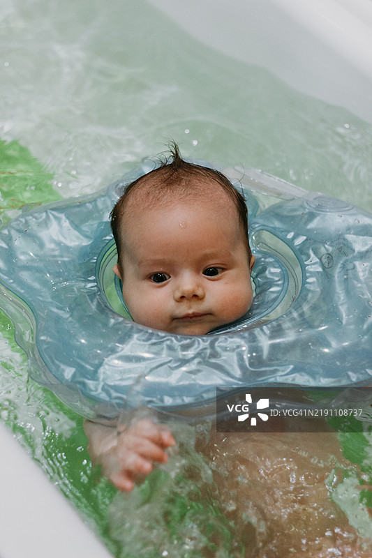 婴儿在浴缸里洗澡，周围有一个圆圈图片素材