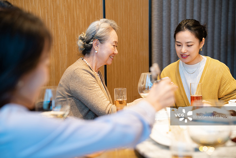 亚洲老年女性与年轻女性一起参加宴会图片素材