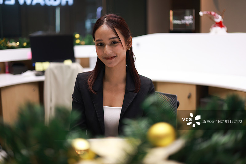 一位迷人的年轻亚洲女商人在现代办公室使用数字平板和智能手机应用进行工作，留有空白空间。图片素材