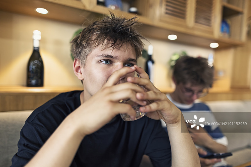 少年在餐厅里喝水，等待点餐。图片素材