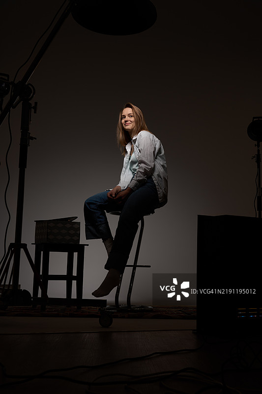 在工作室环境中坐在凳子上的女性图片素材