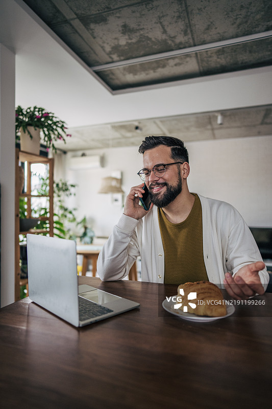 年轻男子在家中办公室打电话图片素材