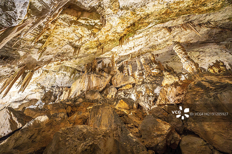 斯洛文尼亚著名旅游景点波斯托伊纳洞穴内照亮的钟乳石和石笋形成的壮丽景观图片素材