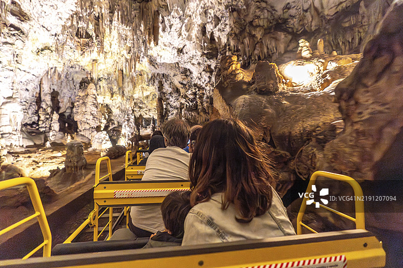游客们在斯洛文尼亚著名景点波斯托伊纳洞穴的壮丽地貌中享受火车之旅图片素材