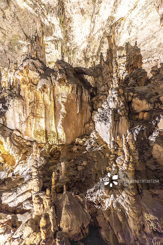 壮观的钟乳石和石笋在斯洛文尼亚的波斯托伊纳洞穴中形成了令人叹为观止的景象，这里是一个受欢迎的旅游目的地。图片素材