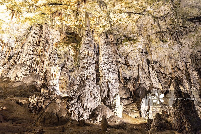 壮观的钟乳石和石笋在斯洛文尼亚著名的旅游景点波斯托伊纳洞穴中形成了令人惊叹的地下景观。图片素材