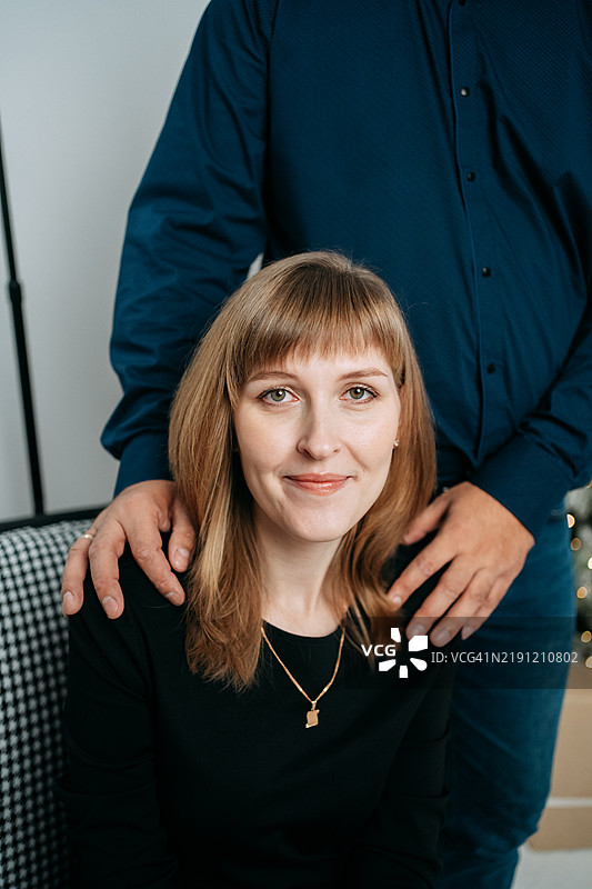 男人站在女人身后，双手放在她的肩膀上，安慰她图片素材