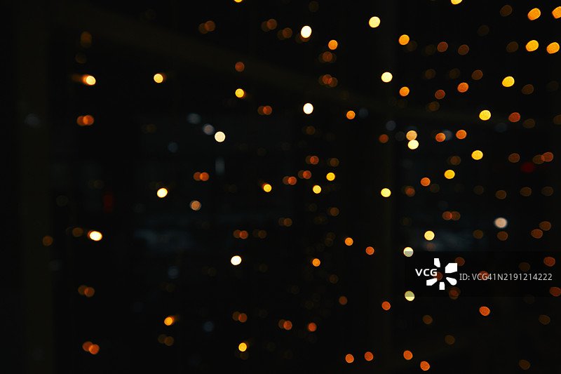 模糊的温暖光点在黑暗背景上图片素材