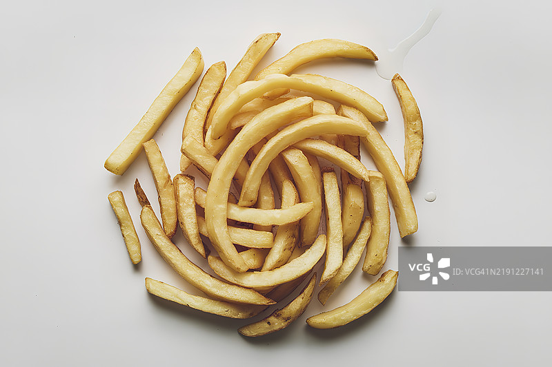 从上方俯视一只白色盘子，盘中盛有炸旋转土豆条。图片素材