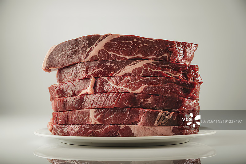 白色背景下盘子里的肉类特写图片素材