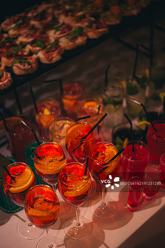 冰镇的鸡尾酒，配以迷迭香装饰，整齐地摆放在自助餐上。图片素材