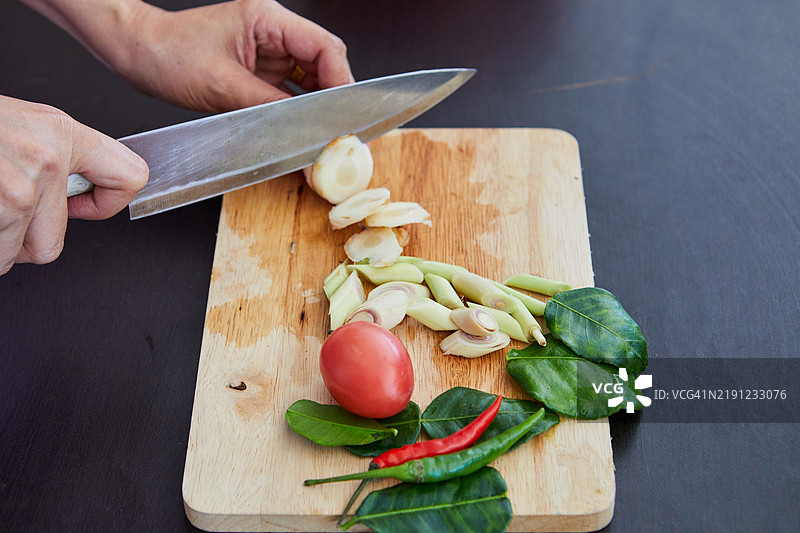 女人在厨房的砧板上切割南姜的手部特写图片素材