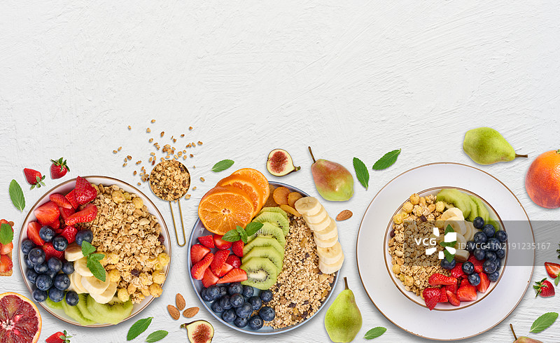 白色背景上的燕麦片和各种水果的盘子，健康早餐图片素材