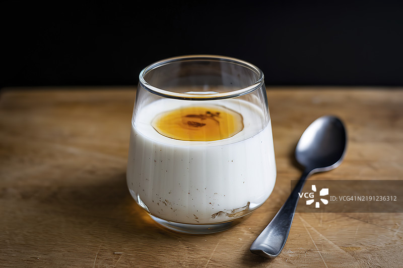 一杯装满自制酸奶并淋上天然蜂蜜的玻璃杯图片素材