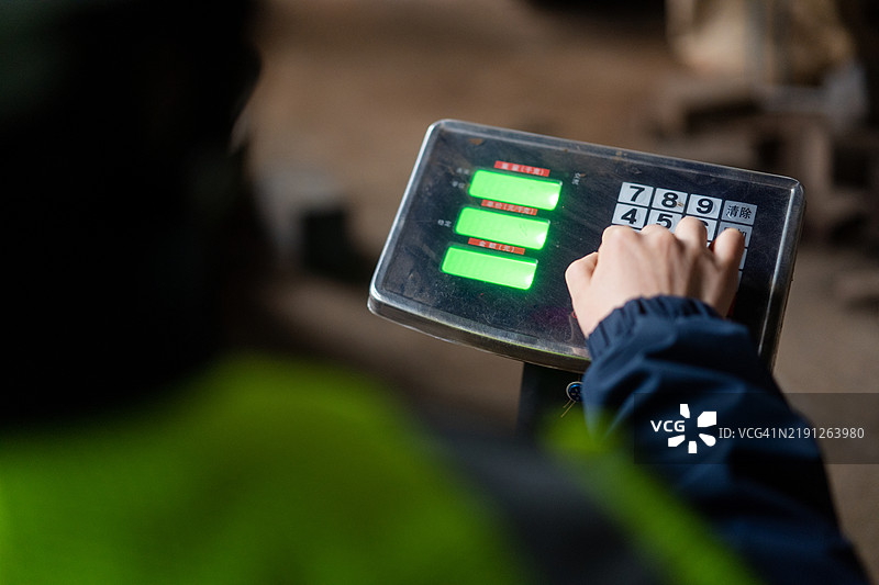 使用电子秤称重。图片素材