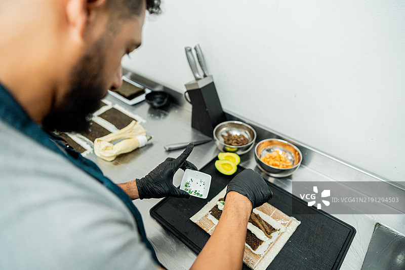 男子在寿司吧厨房烹饪的特写镜头图片素材