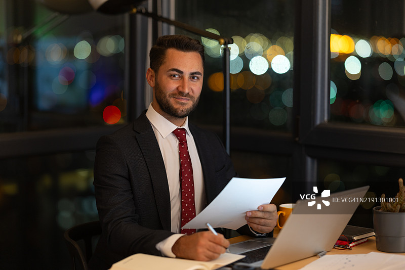 在城市景观下的办公室里加班的商人图片素材