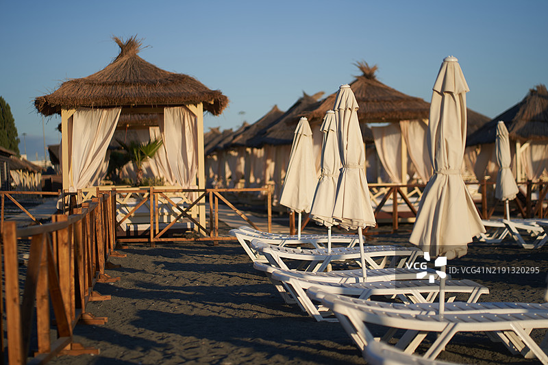 海岸上的凉亭和日光浴椅。图片素材