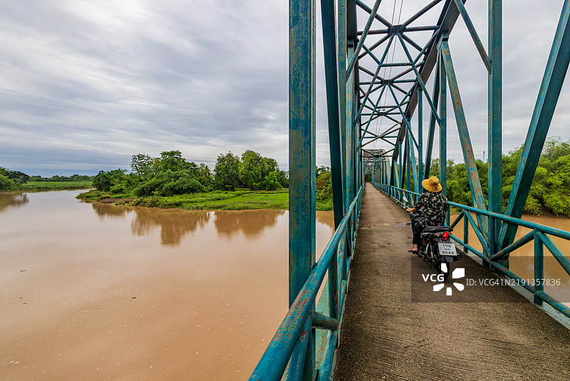 泰国摩托车手在青绿色的桥上。图片素材