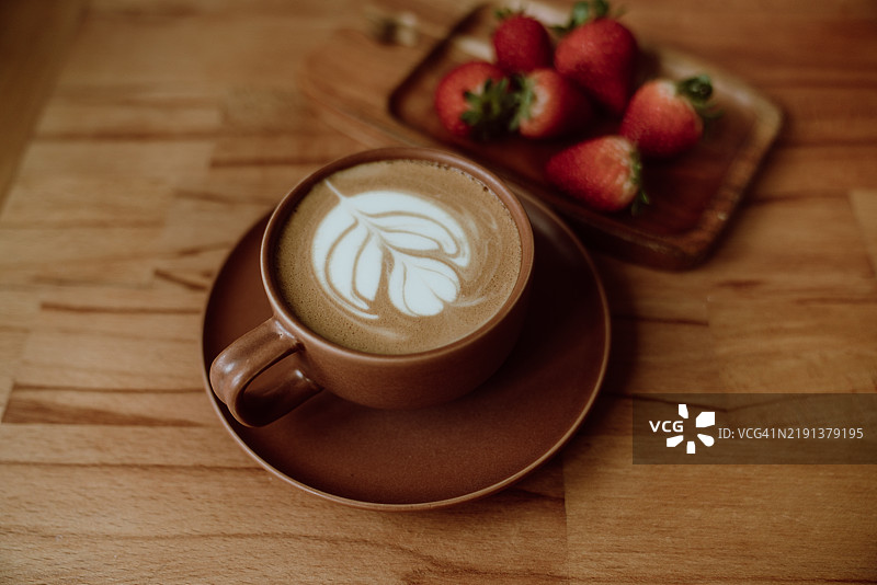自制草莓咖啡拿铁放在木盘上图片素材