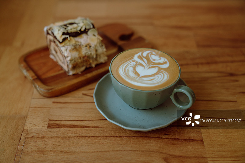自制咖啡拿铁与一片蛋糕放在木盘上图片素材