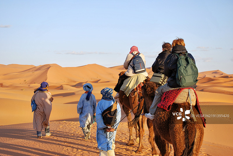 当地向导带领游客在摩洛哥的埃尔格·舍比骑骆驼图片素材