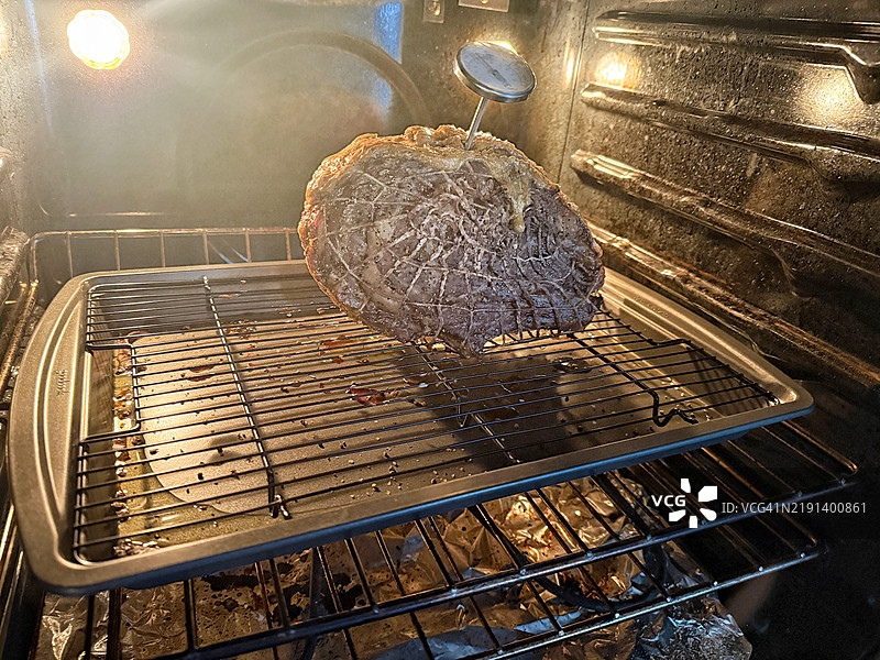 在郊区的烤箱中烹饪节日晚餐的肋眼牛排图片素材